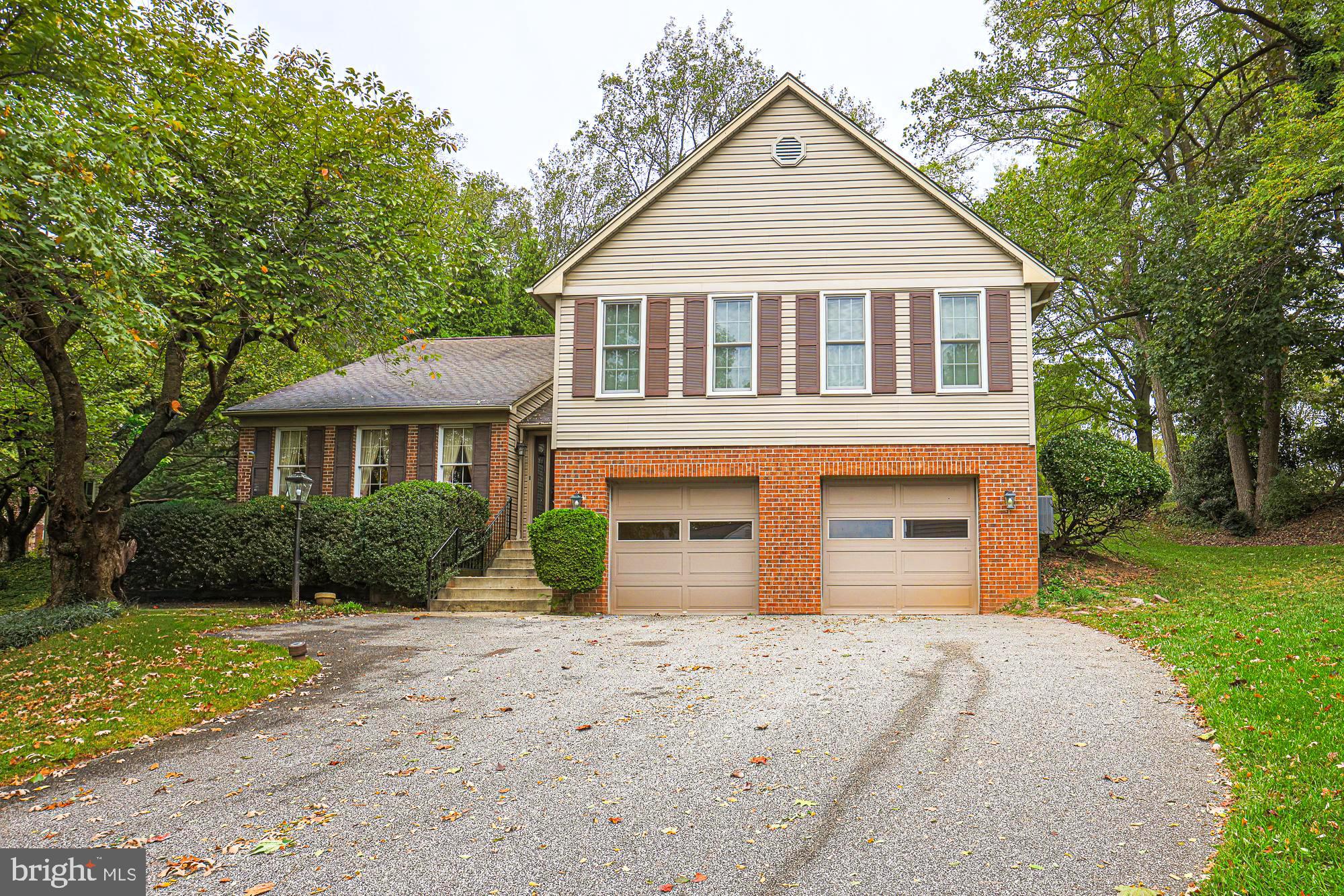 a front view of a house with a yard and trees