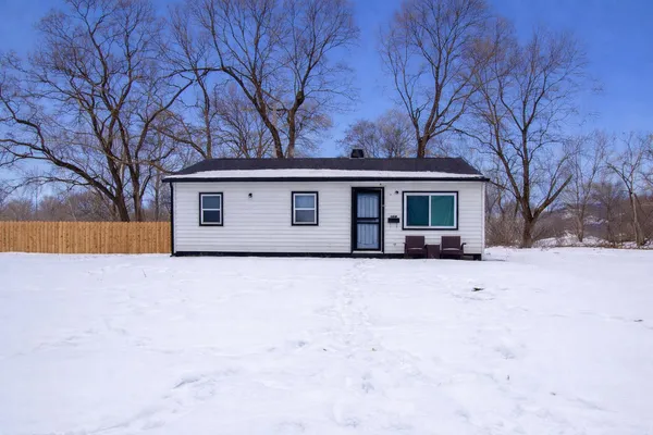front view of a house with a yard covered in snow