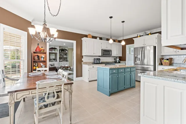 a kitchen with kitchen island granite countertop a stove a sink a refrigerator and a refrigerator