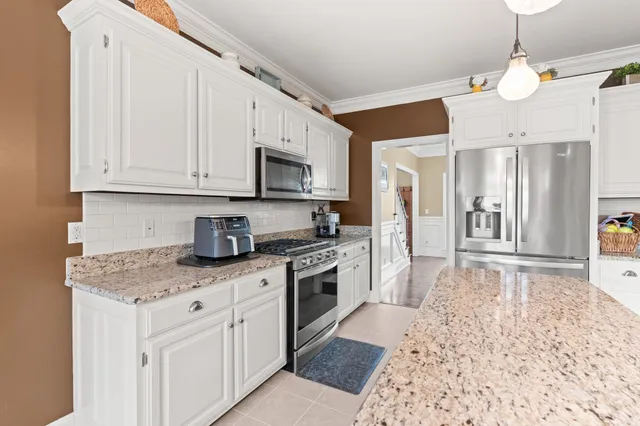 a kitchen with stainless steel appliances granite countertop a stove a sink and a refrigerator