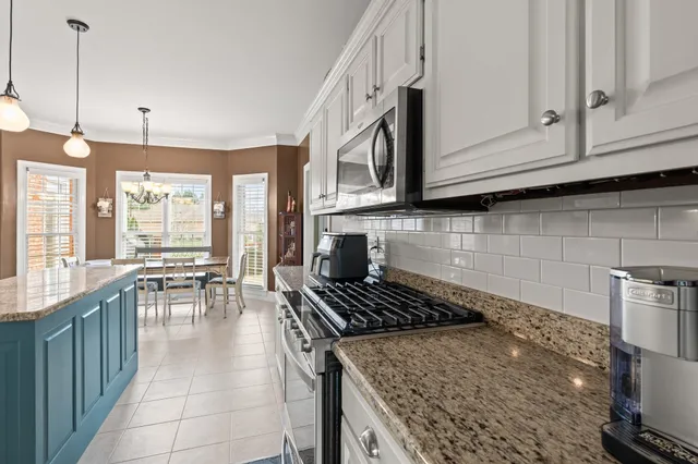 a kitchen with stainless steel appliances granite countertop a stove a sink and a microwave