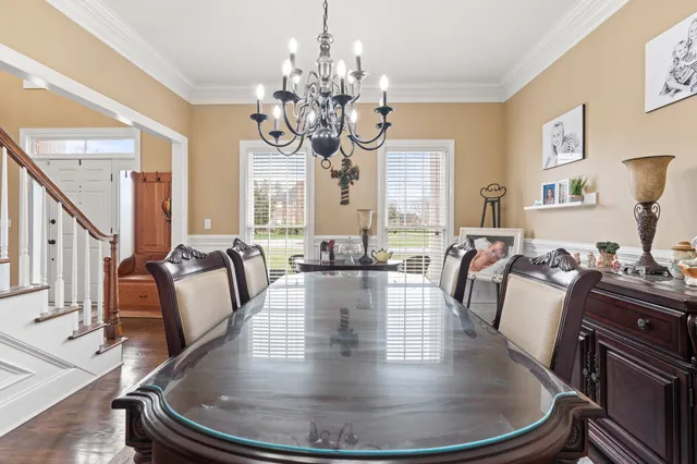 a view of a dining room with furniture a chandelier and wooden floor