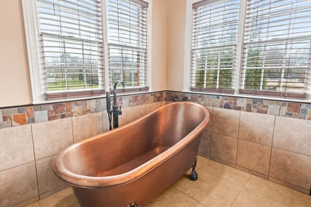a large bathroom with a large tub sink and window