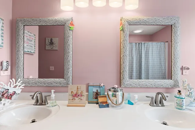 a bathroom with a sink double vanity granite and a mirror