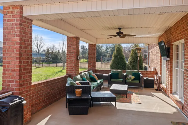 a living room with furniture windows and a ceiling fan