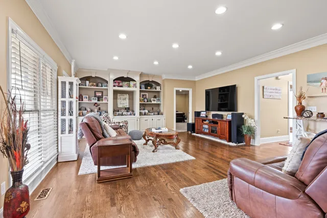 a living room with furniture flat screen tv and wooden floor