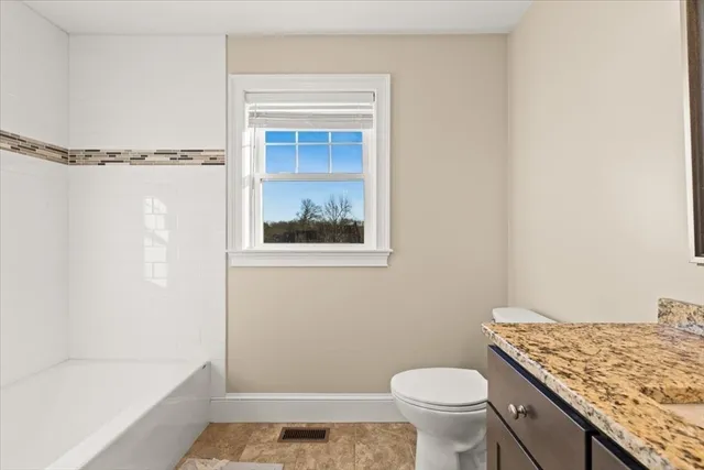 a bathroom with a granite countertop sink toilet and shower