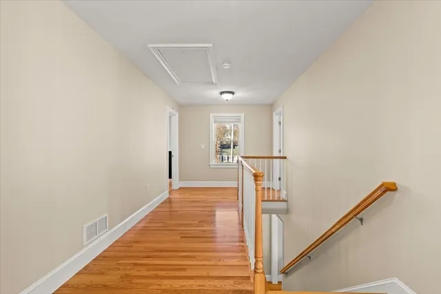 a view of a hallway with wooden floor and staircase