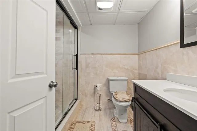 a bathroom with a sink a toilet a shower and a mirror