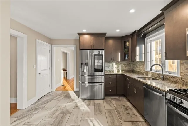 a kitchen with stainless steel appliances granite countertop a refrigerator and a sink