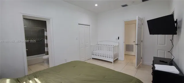 a bedroom with a chair and potted plant on a table
