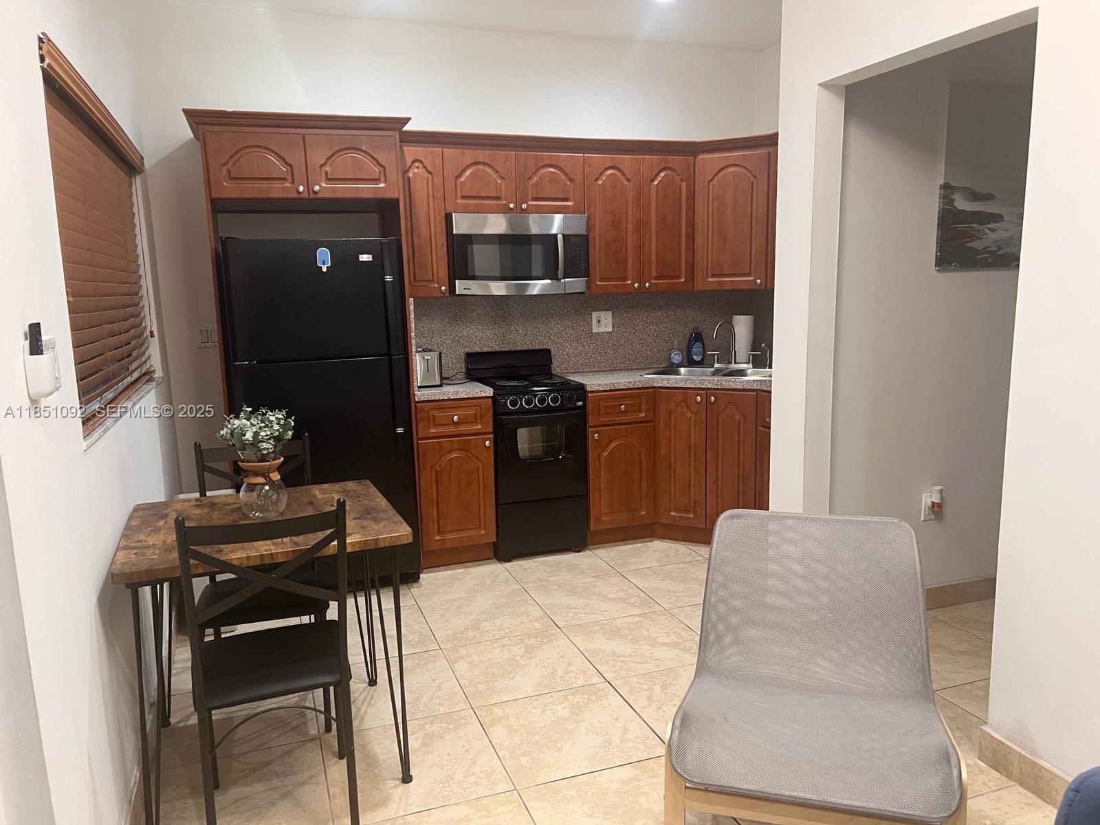 1721 Southwest 24th Terrace Miami, FL 33145 - Photo 62 of 80 a kitchen with stainless steel appliances kitchen island granite countertop a refrigerator and a stove top oven