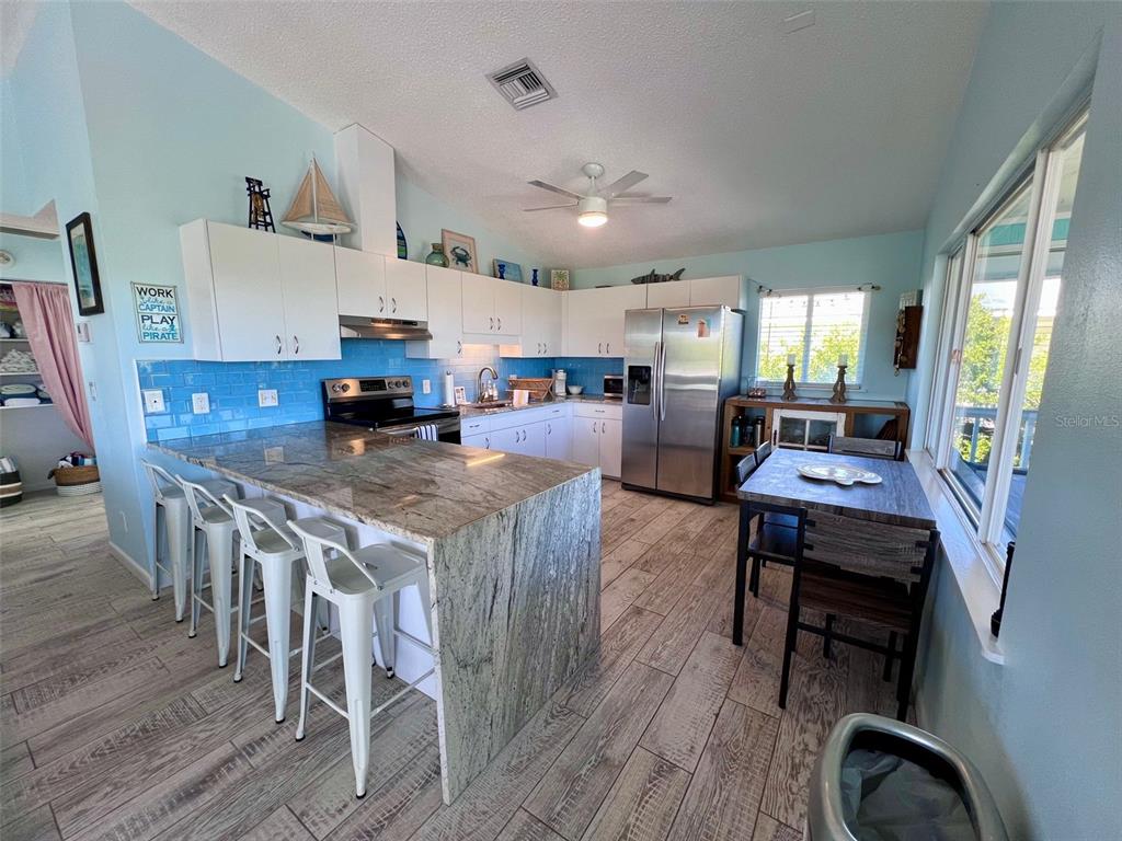 9568 Buccaneer Trail Boca Grande, FL 33921 - Photo 26 of 49 a view of kitchen and dining room with wooden floor