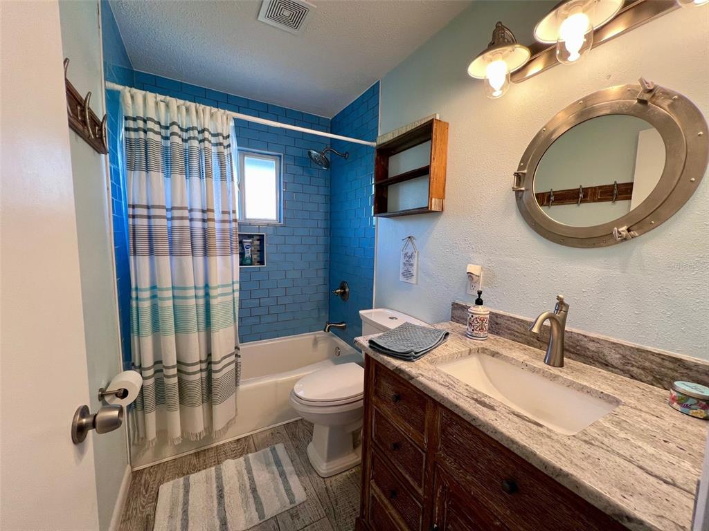 9568 Buccaneer Trail Boca Grande, FL 33921 - Photo 34 of 49 a bathroom with a granite countertop bathtub sink vanity mirror and toilet