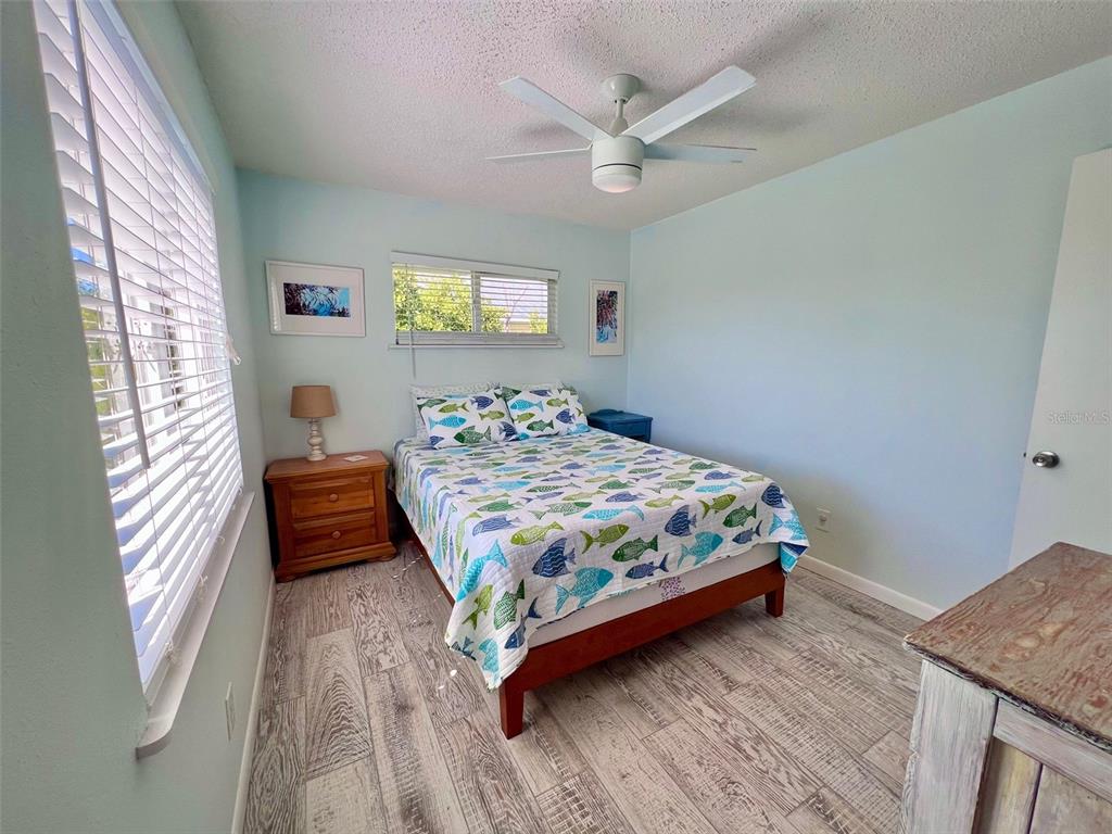 9568 Buccaneer Trail Boca Grande, FL 33921 - Photo 38 of 49 a bedroom with a bed and a chandelier