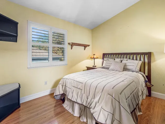 a bedroom with a bed and a potted plant