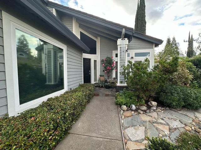 a pathway of a house with potted plants