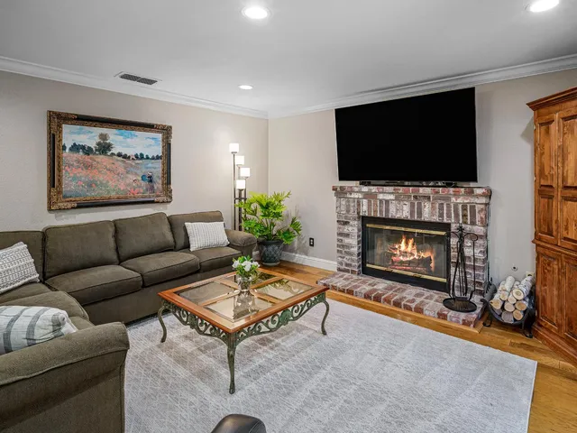 a kitchen with stainless steel appliances granite countertop a stove top oven a sink a dining table and chairs with wooden floor