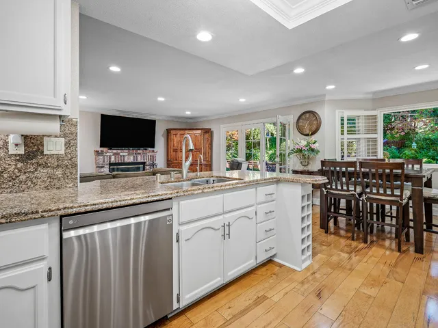 a kitchen with granite countertop a sink a counter top space stainless steel appliances and cabinets