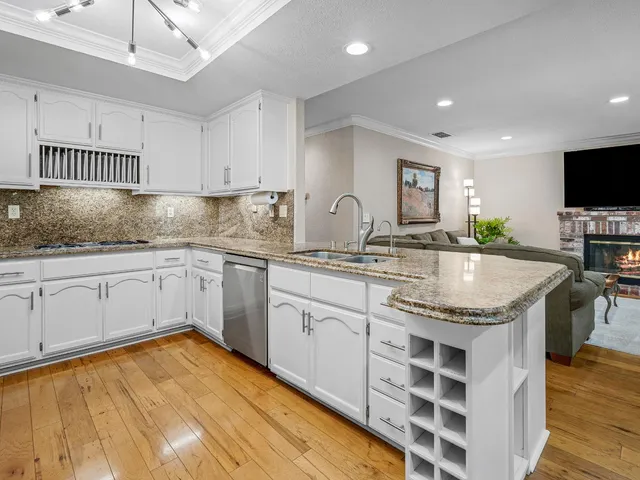 a kitchen with granite countertop white cabinets and refrigerator