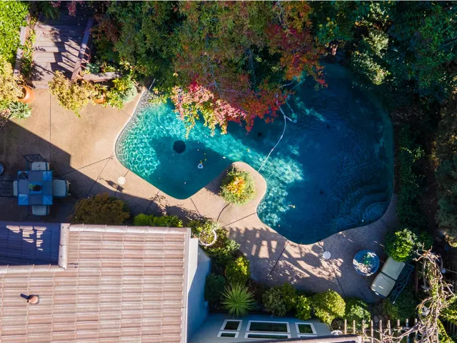 an aerial view of a house with a yard and potted plants