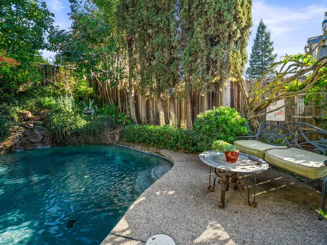a patio with table and chairs and potted plants