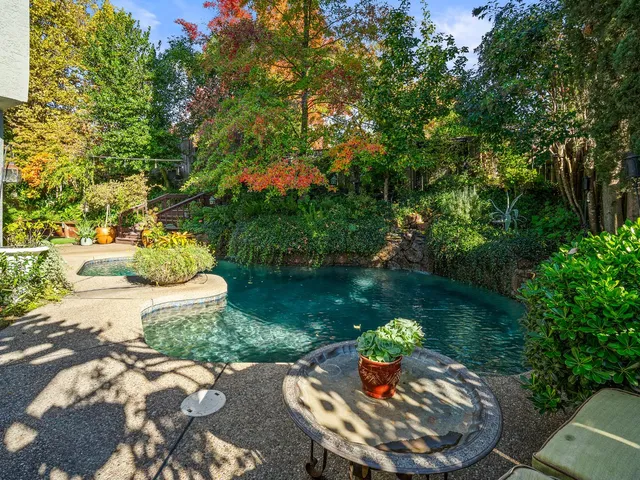 a front view of a house with a yard and swimming pool