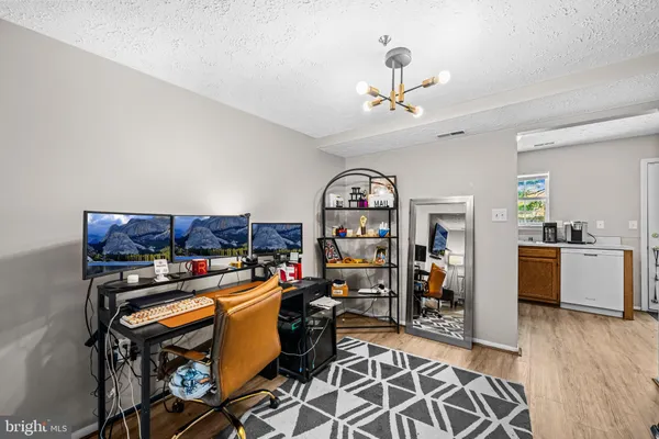 a kitchen with stainless steel appliances granite countertop a refrigerator oven a sink dishwasher and white cabinets with wooden floor