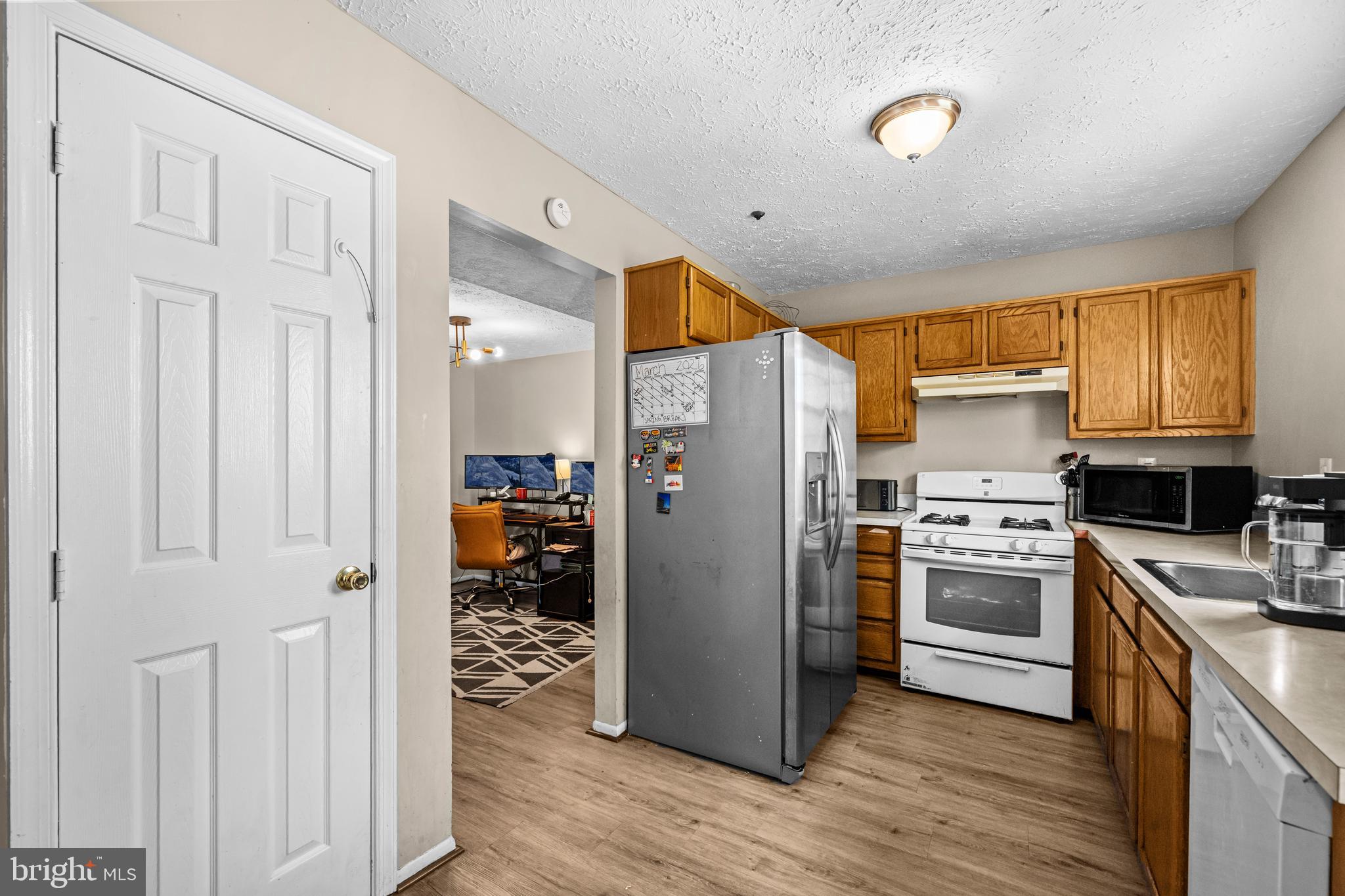 5818 Springfish Place Waldorf, MD 20603 - Photo 10 of 31 a kitchen with stainless steel appliances granite countertop a refrigerator oven a sink dishwasher and white cabinets with wooden floor