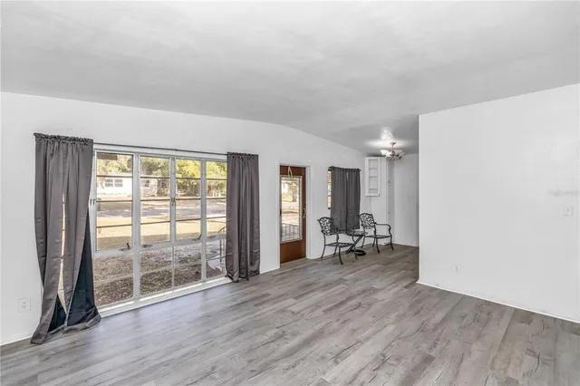 an empty room with wooden floor and furniture