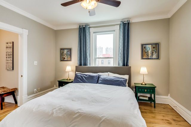 5626 North Ridge Avenue Chicago, IL 60660 - Photo 14 of 27 a bedroom with a bed and a chandelier