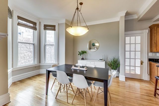 5626 North Ridge Avenue Chicago, IL 60660 - Photo 7 of 27 a dining room with wooden floor a chandelier a glass table and chairs
