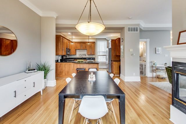 5626 North Ridge Avenue Chicago, IL 60660 - Photo 9 of 27 a kitchen with stainless steel appliances granite countertop a stove a sink a refrigerator dining table and chairs with wooden floor
