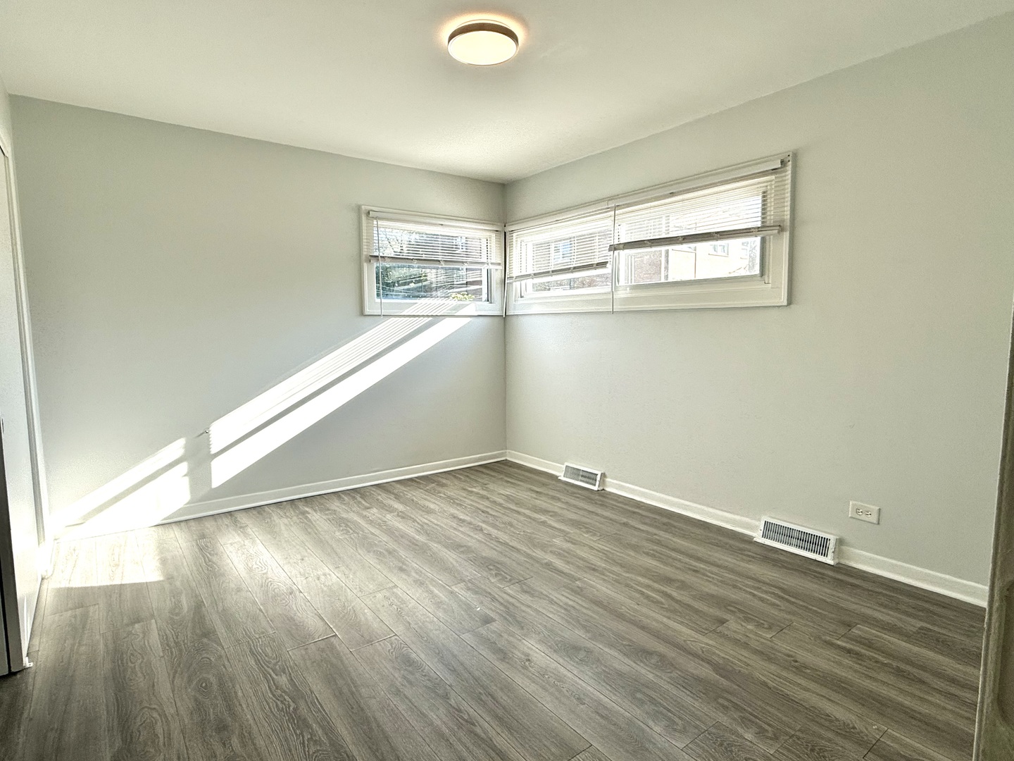 231 Callan Avenue, Unit 2N Evanston, IL 60202 - Photo 8 of 8 an empty room with wooden floor and windows