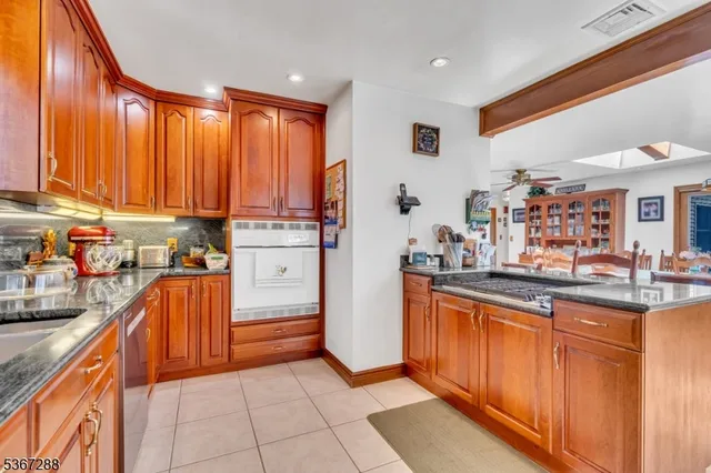 a kitchen with stainless steel appliances granite countertop a refrigerator and a stove top oven