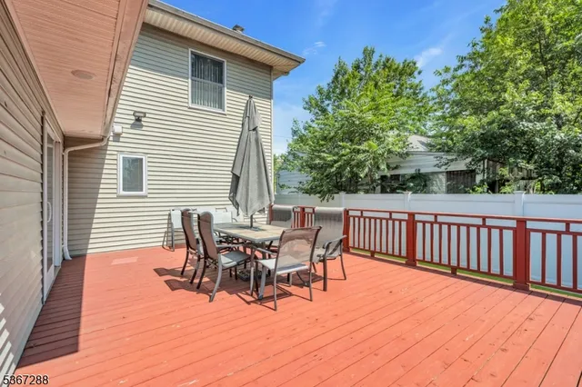 a view of a patio with table and chairs with wooden floor and fence