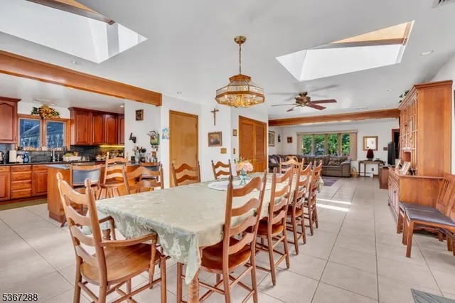 a dining area with stainless steel appliances kitchen island granite countertop a table chairs and a view of living room