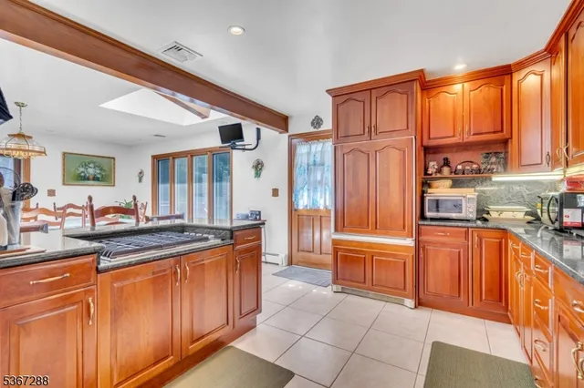 a large kitchen with stainless steel appliances granite countertop a refrigerator and a stove top oven