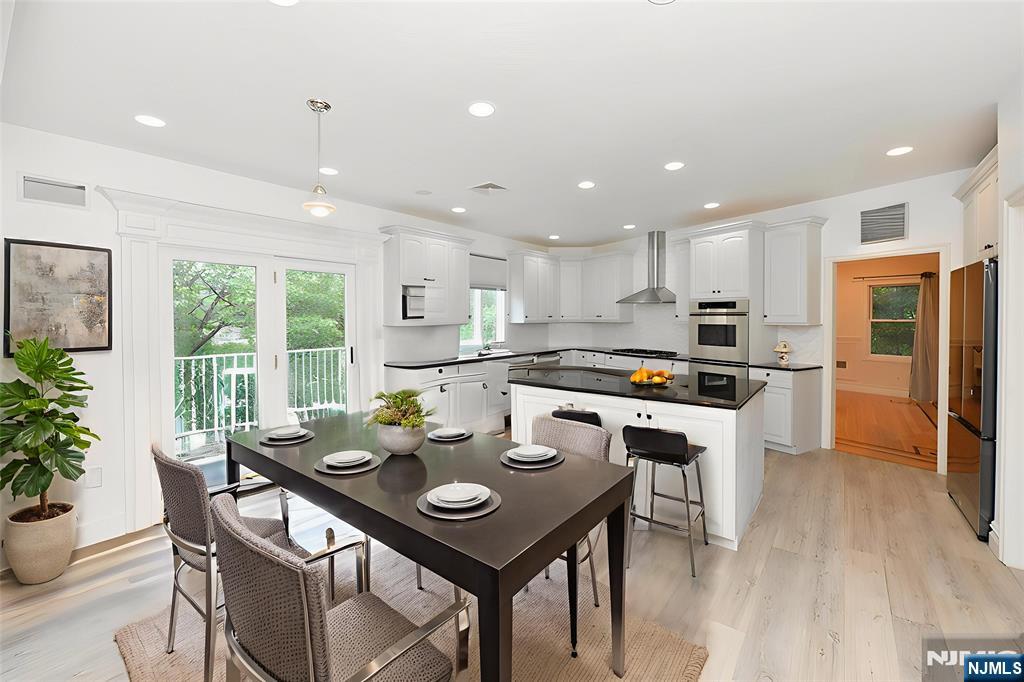 2186 Jones Road Fort Lee, NJ 07024 - Photo 6 of 27 a kitchen with stainless steel appliances granite countertop a stove a refrigerator a kitchen island with a stove and white cabinets