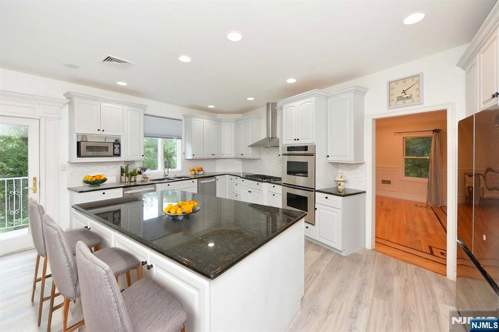2186 Jones Road Fort Lee, NJ 07024 - Photo 7 of 27 a kitchen with stainless steel appliances granite countertop a refrigerator a sink dishwasher a stove and white countertops with wooden floor