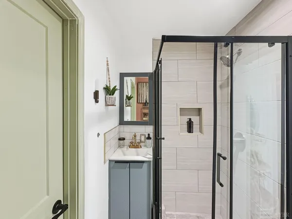 a bathroom with a shower sink and mirror with shower