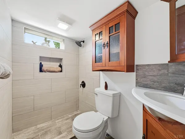 a bathroom with a sink a toilet and shower