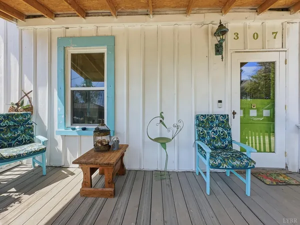 a balcony with wooden floor table and chairs