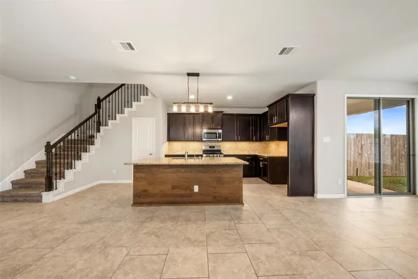 a large kitchen with kitchen island granite countertop a large counter top and stainless steel appliances