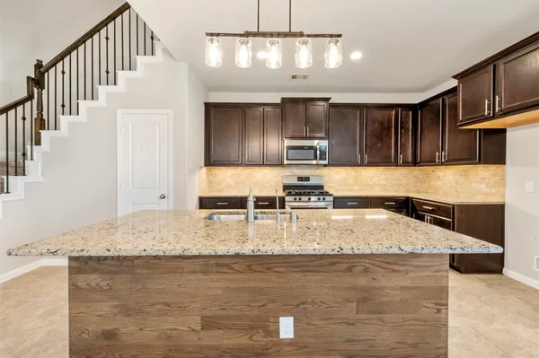 a kitchen with granite countertop stainless steel appliances and wooden cabinets