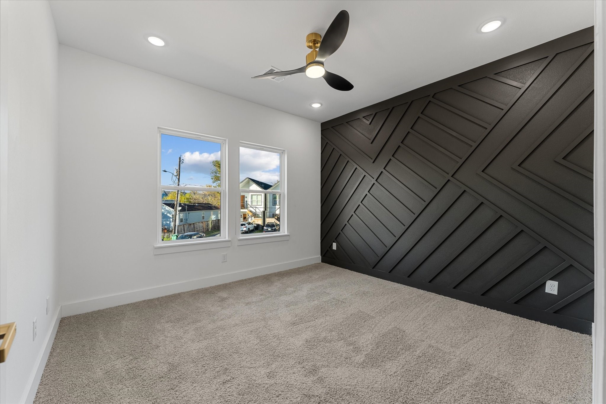 1010 Calvin Street Houston, TX 77088 - Photo 16 of 20 Bedroom features a modern design with a striking black accent wall and geometric pattern. Recessed lighting. Perfect for a stylish bedroom or office. Photos are from builders previously built model, same floor plan and finishes.