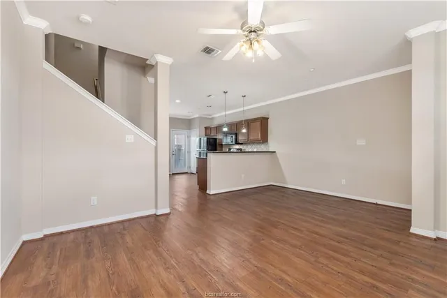 a view of a big room with wooden floor and ceiling fan
