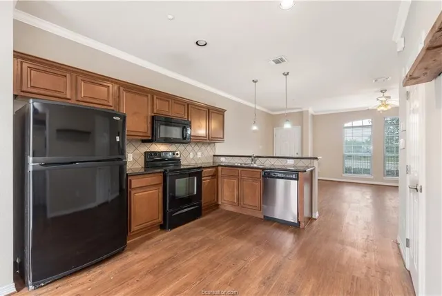 a kitchen with granite countertop stainless steel appliances and wooden cabinets