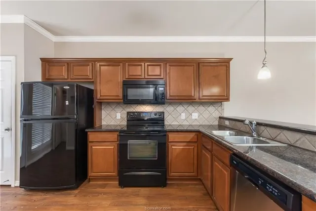 a kitchen with stainless steel appliances granite countertop a refrigerator and a stove top oven