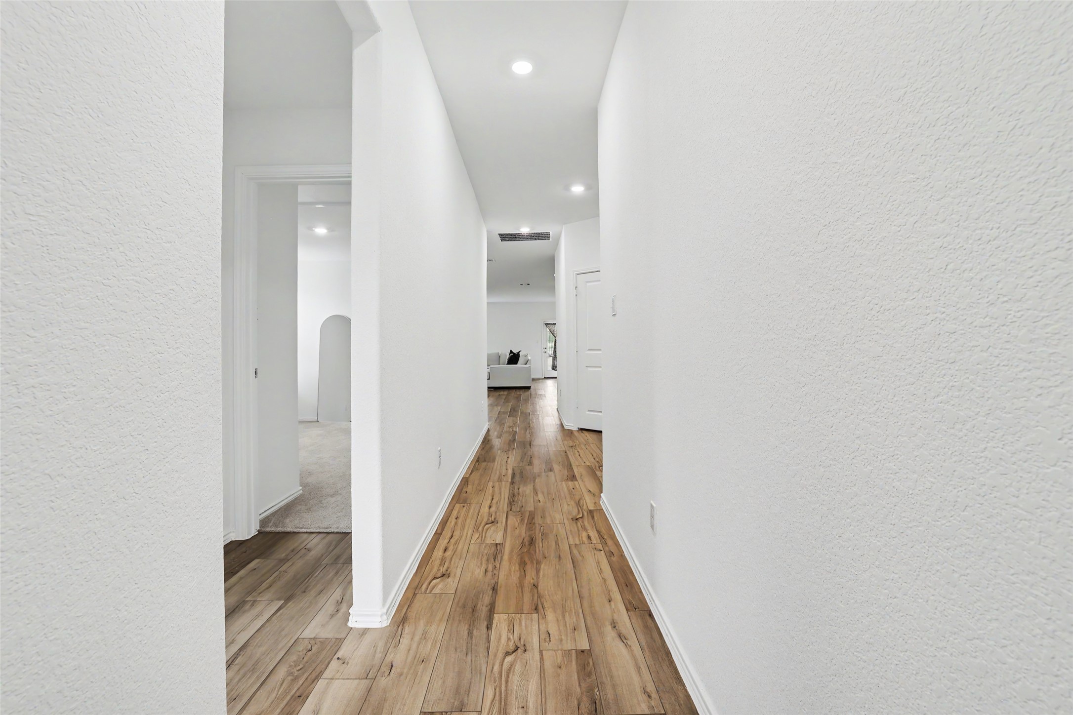 2333 Four Waters Loop Georgetown, TX 78628 - Photo 5 of 35 Long hallway featuring wood-finish flooring, white walls, and recessed lighting